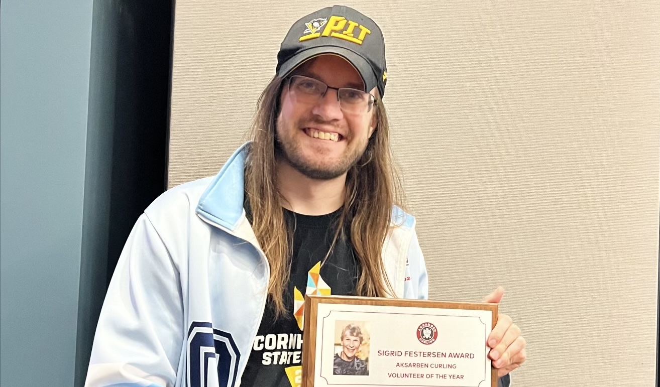 Nic Ridder holding the Sigrid Festersen Volunteer of the Year Award plaque